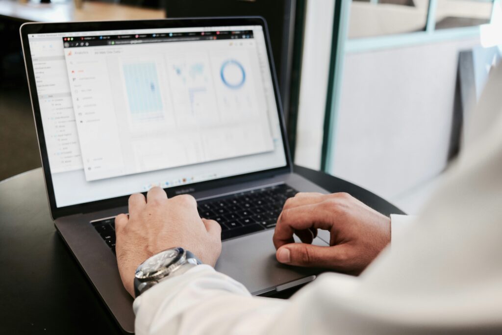 Person arbejder på digital marketing-strategi ved laptop med analyser på skærmen